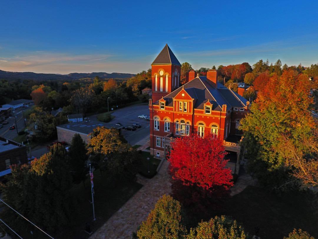 An aerial view of the courthouse in Fayette County, WV. The image was captured in the fall, with the trees turning brilliant shades of red and orange.